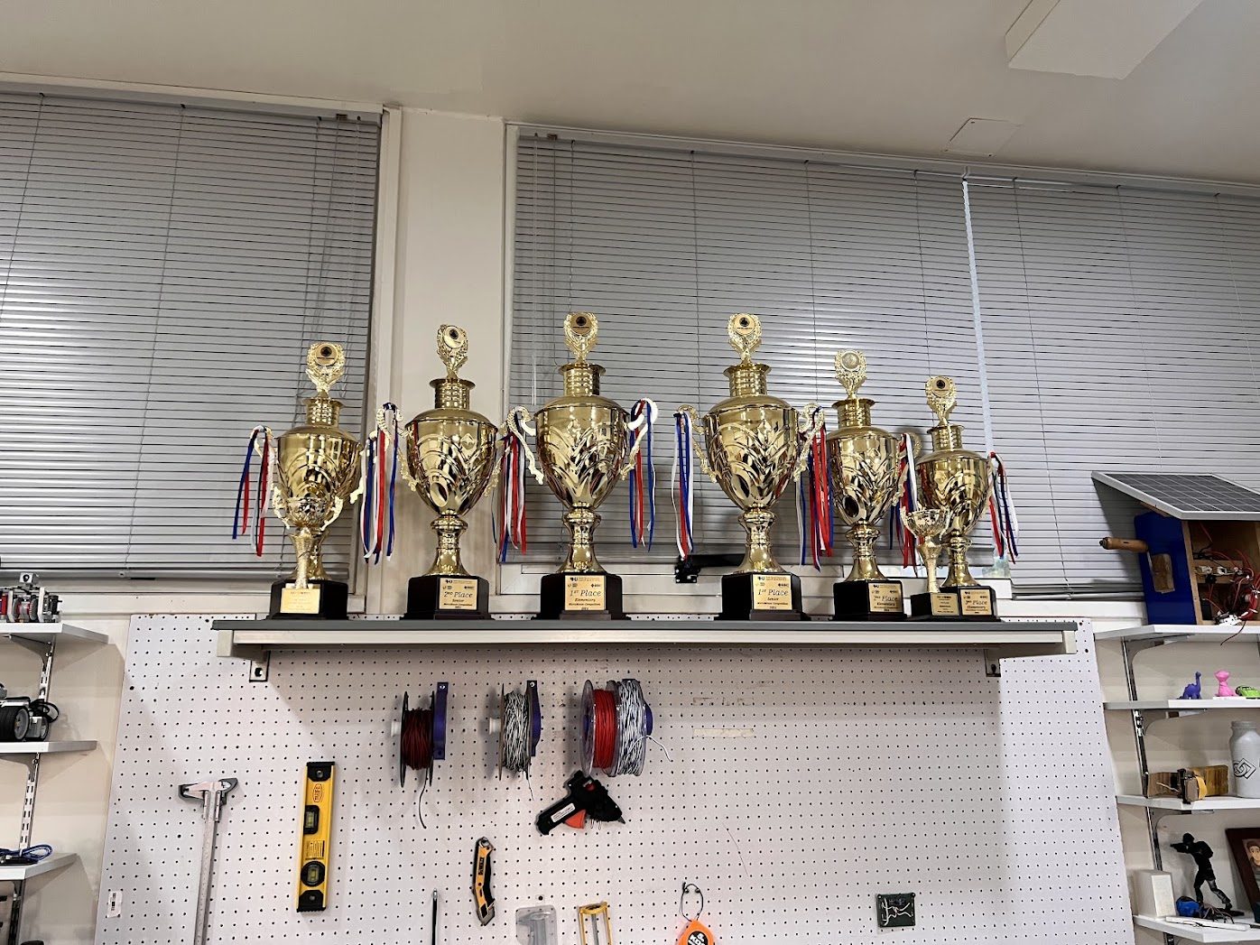 A row of seven gold trophies on a shelf in the RHU engineering lab.
